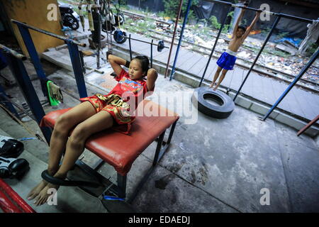 Bangkok, Thailand. 7. November 2014. Kämpferin Züge in einem Box-Raum befindet sich in einem Slum von Bangkok. Jeden Abend, Kinder von Bangkok kommt zu üben Muay-Thai-Boxen in einem Slum der Hauptstadt, genügend Erfahrung zu bekommen, bevor die "echte" in einer Arena, umgeben von Tausenden von Menschen zu kämpfen, sie starten, sobald sie (ca. 4-5 Jahre alt), mit der Hoffnung, ein berühmter Boxer können und raus aus dem Armenviertel wo sie leben. © Guillaume Payen/ZUMA Wire/ZUMAPRESS.com/Alamy Live-Nachrichten Stockfoto