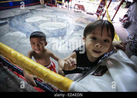 Bangkok, Thailand. 7. November 2014. Kinder trainieren Sie an einem Boxsäcke und Holm in einem Schulungsraum Boxen befindet sich in einem Slum von Bangkok. Jeden Abend, Kinder von Bangkok kommt zu üben Muay-Thai-Boxen in einem Slum der Hauptstadt, genügend Erfahrung zu bekommen, bevor die "echte" in einer Arena, umgeben von Tausenden von Menschen zu kämpfen, sie starten, sobald sie (ca. 4-5 Jahre alt), mit der Hoffnung, ein berühmter Boxer können und raus aus dem Armenviertel wo sie leben. © Guillaume Payen/ZUMA Wire/ZUMAPRESS.com/Alamy Live-Nachrichten Stockfoto