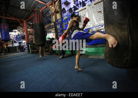 Bangkok, Thailand. 7. November 2014. Kinder trainieren Sie an einem Boxsäcke und Holm in einem Schulungsraum Boxen befindet sich in einem Slum von Bangkok. Jeden Abend, Kinder von Bangkok kommt zu üben Muay-Thai-Boxen in einem Slum der Hauptstadt, genügend Erfahrung zu bekommen, bevor die "echte" in einer Arena, umgeben von Tausenden von Menschen zu kämpfen, sie starten, sobald sie (ca. 4-5 Jahre alt), mit der Hoffnung, ein berühmter Boxer können und raus aus dem Armenviertel wo sie leben. © Guillaume Payen/ZUMA Wire/ZUMAPRESS.com/Alamy Live-Nachrichten Stockfoto