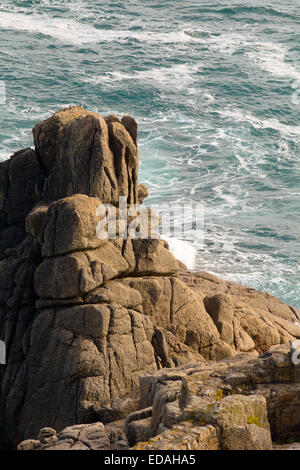 Wellen brechen sich am Felsen bei Porthcurno, Cornwall, England an sonnigen Herbsttag Stockfoto