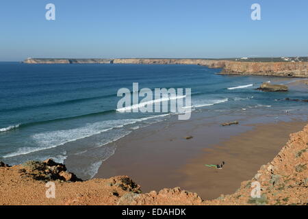 perfekte Surfbedingungen an Tonel Strand Sagres mit Kap St. Vincent Leuchtturm im Hintergrund Stockfoto