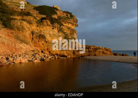 gelbe farbige Klippen am Figuiera Strand in der untergehenden Sonne glühen Stockfoto