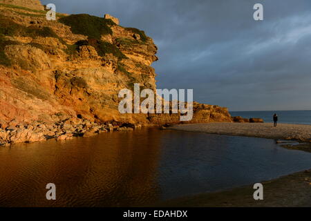 gelbe farbige Klippen am Figuiera Strand in der untergehenden Sonne glühen Stockfoto