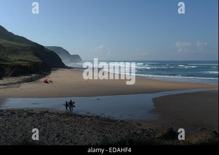 Dawn Patrol. Surfer am Strand mit blauem Himmel und Meer Nebel steigt sanft in die Wärme der Morgensonne Stockfoto