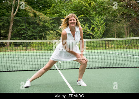 Sportlerin Lockerungsübungen bis auf ein Tennis Court gesunde Bewegung und halten Sie sich fit Stockfoto