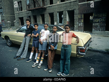 USA, SOUTH BRONX, NEW YORK CITY - AUGUST 1977. South Bronx Teenager vor verlassenen Mietshaus ausgebrannten Gebäuden, South Bronx, New York City, USA. Stockfoto