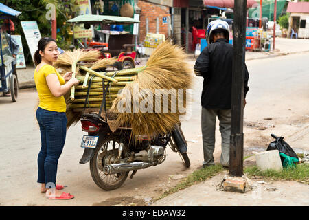 Frau kauft einen Besen von einem Motorrad Besen Verkäufer, Siem Reap, Kambodscha Stockfoto