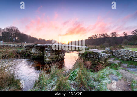 Eine frostige Winter Sonnenaufgang über eine alte Granit-Klöppel-Brücke bei Postbridge auf Dartmoor National Park in Devon Stockfoto