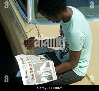 ELVIS PRESLEY BEERDIGUNG, MEMPHIS, TENNESSEE, USA 18. AUGUST 1977.  Trauernder kündigt Elvis Presley Tod am 16. August 1977 außerhalb Graceland, Memphis Lokalzeitung lesen. Stockfoto