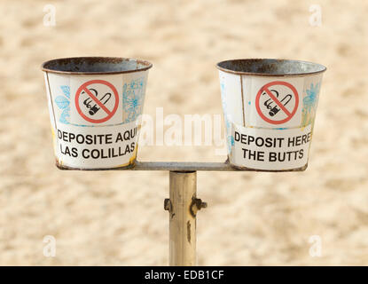 Container für die Entsorgung von Zigarettenkippen am Strand in Spanien. Eine in Englisch, die andere auf Spanisch. Stockfoto