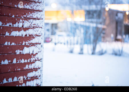 Rotes Holzhaus-Panel in einem verschneiten Tag Stockfoto