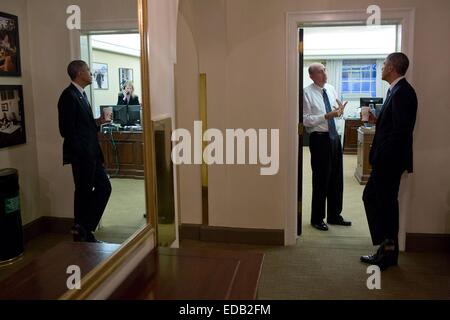 US-Präsident Barack Obama in den Spiegel reflektiert wird, wie er vor seinem Büro im zweiten Stock des Westflügels des weißen Hauses 19. November 2014 in Washington, DC mit Neil Eggleston, Berater des Präsidenten, spricht. Stockfoto