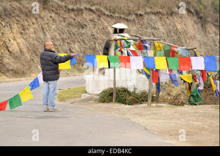 Mann hängen Gebetsfahnen in Pele La Bergpass, Bhutan Stockfoto