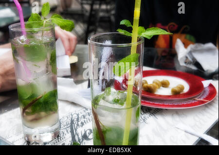 Café La Lamparilla downtown Havanna, mit zwei hohe Gläser Mojitos und Oliven während touristische Buch liest. Entspannung, ferienhäuser, Cocktail rum Essen trinken. Stockfoto