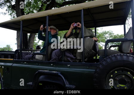 Touristen fotografieren Vögel aus einer Pirschfahrt Fahrzeug während auf Safari in Botswana Stockfoto