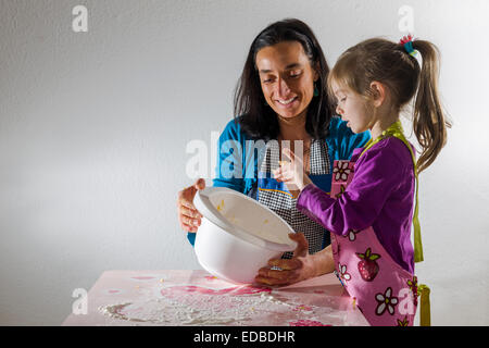 Mädchen, 3 Jahre, und ihre Mutter, Backen, mischen Zutaten in einer Schüssel weiß Stockfoto