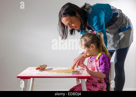 Mädchen, 3 Jahre, und ihre Mutter, Weihnachtsplätzchen Backen Stockfoto