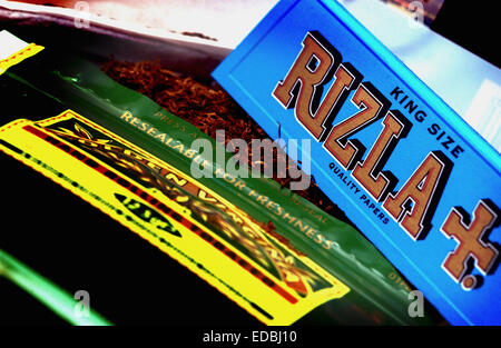 Bild zeigt ein Paket von Rizla Blau Zigarettenpapier und einen Beutel Golden Virginia-Tabak. Stockfoto