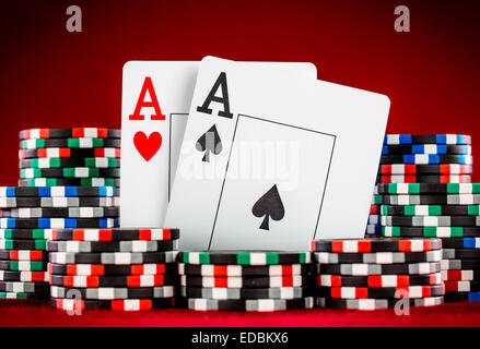 Stapel Chips und zwei Asse auf dem Tisch auf den roten Filz - Poker-Spiel-Konzept Stockfoto