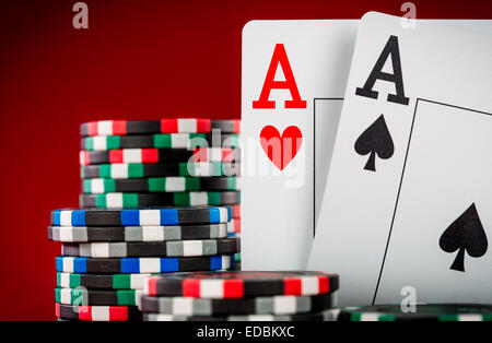 Stapel Chips und zwei Asse auf dem Tisch auf den roten Filz - Poker-Spiel-Konzept Stockfoto