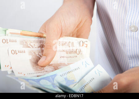 Ein Mann zählen verschiedene Stückelungen von Euro-Banknoten Stockfoto