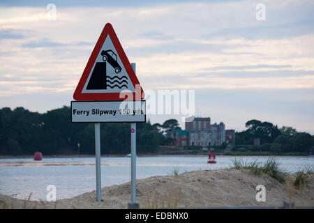 Fähre Slipway 150 YDS Straßenschild in Studland mit Poole Harbour und Brownsea Castle auf Brownsea Island in der Ferne, Dorset UK im Juli Stockfoto