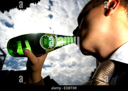 Ein Mann trinkt Perrier Mineralwasser. Stockfoto