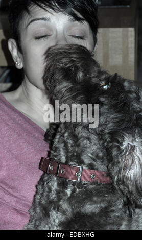 Hund lecken Gesicht eines kurzen blonden Frau und gab ihr einen Kuss Stockfoto