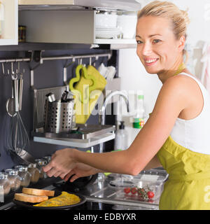 Junge Mutter kochen zu Hause. Stockfoto
