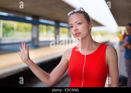 Junge Frau auf der Plattform des Bahnhofs. Stockfoto