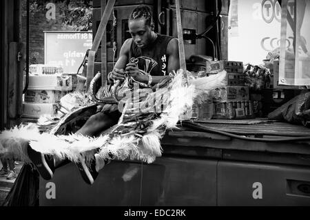 LONDON, UK 24. August 2014: Notting Hill Carnival. Junger Mann setzt seinen Karnevalskostüm Feinschliff. Stockfoto