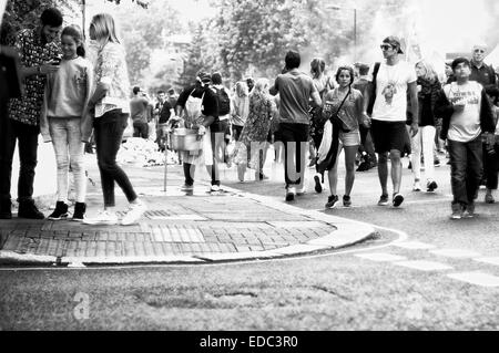 24. August 2014, wäscht Notting Hill Carnival London - UK Frau Pfanne auf dem Bürgersteig, während Masse um auf der Straße wanderte Stockfoto