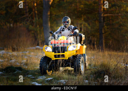 Horizontale Porträt eines Mannes in Helm und Schutzbrille in die Kamera schaut beim Sitzen auf Geländewagen. Stockfoto