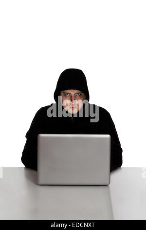 Hacker im schwarzen Kleid auf einem silbernen Laptopcomputer isoliert auf weißem Hintergrund Stockfoto