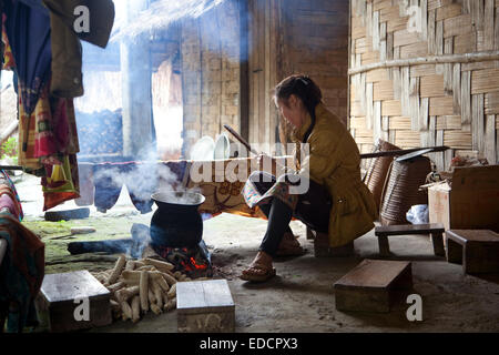 Lao Frau Kochen auf offenem Feuer in traditionellen Bambushaus im ländlichen Dorf im nördlichen Laos Stockfoto