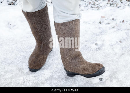 Männliche Füße mit russischen fühlte Stiefel Winter mit Schnee und Eis unterwegs Stockfoto