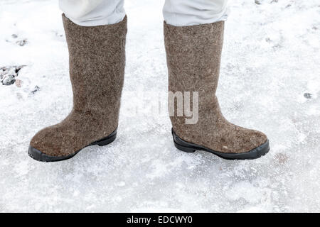 Männliche Füße mit traditionellen russischen fühlte Stiefel im Winter verschneiten Straße Stockfoto