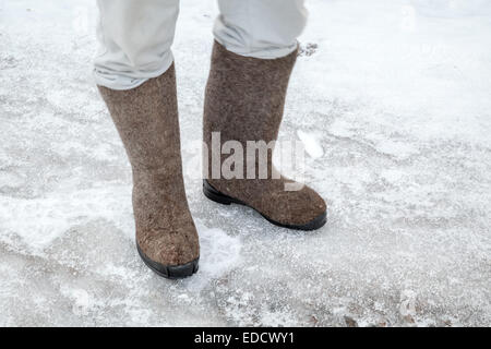 Füße mit traditionellen russischen fühlte Stiefel Winter mit Schnee und Eis unterwegs Stockfoto