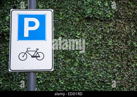 Fahrrad-Parken Zeichen an der Wand des Efeus Stockfoto