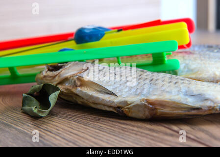 Getrocknete Roach - Vobla und Ausrüstung für die Fischerei mit einem Schwimmer auf einem Holztisch Stockfoto