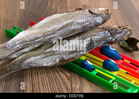 Getrocknete Roach - Vobla und Ausrüstung für die Fischerei mit einem Schwimmer auf einem Holztisch Stockfoto