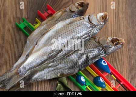 Getrocknete Roach - Vobla und Ausrüstung für die Fischerei mit einem Schwimmer auf einem Holztisch Stockfoto