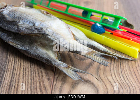 Getrocknete Roach - Vobla und Ausrüstung für die Fischerei mit einem Schwimmer auf einem Holztisch Stockfoto