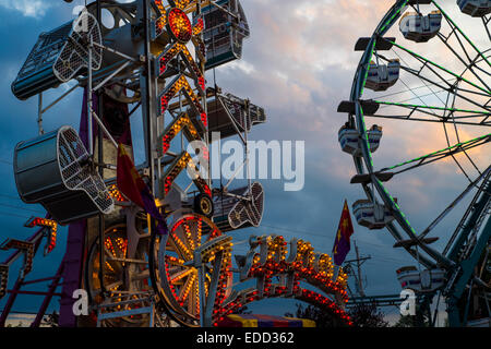 Unterhaltung Fahrten auf einer Kirmes bei Sonnenuntergang. Stockfoto