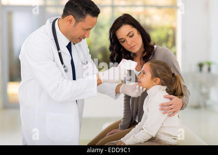 mittleren Alter pädiatrische Arzt Temperaturmessung von kleinen Patienten Stockfoto