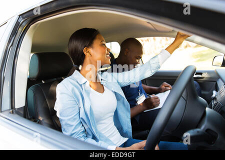 Afrikanische Fahrschüler einstellen Rückspiegel vor eine Fahrprüfung Stockfoto