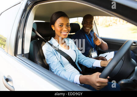 glückliche junge Afrikanerin unter Fahrstunden vom Ausbilder Stockfoto