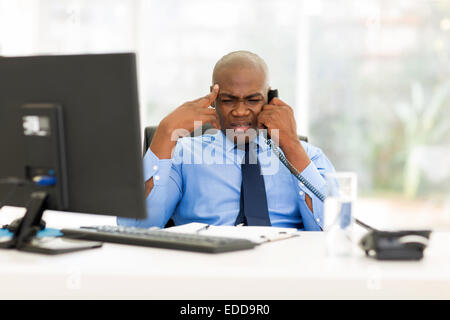 verwirrt afrikanischen Geschäftsmann Gespräch am Telefon im Büro Stockfoto