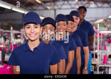 Gruppe von Maschinisten Line-up in Kleiderfabrik Stockfoto