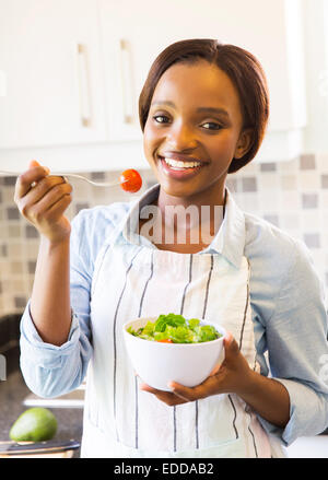 Porträt von glücklich afroamerikanische Mädchen essen grünen Salat Stockfoto